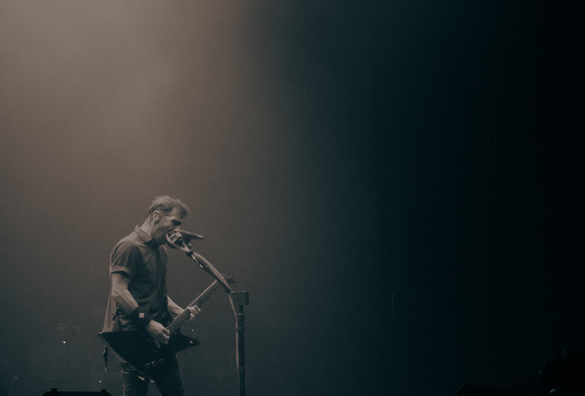 Guitarist leaning into the mic in heavy stage haze at Yaamava Theater